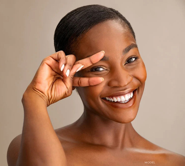 stock image of African model holding her two fingers under her eye