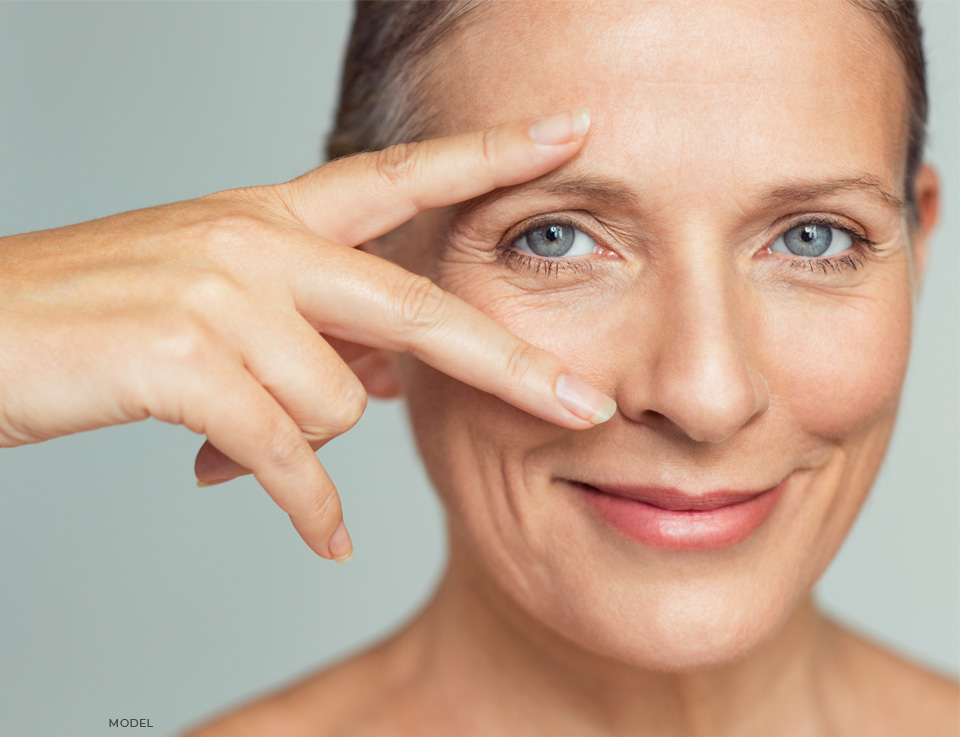 stock image of model showing her eyes under two fingers