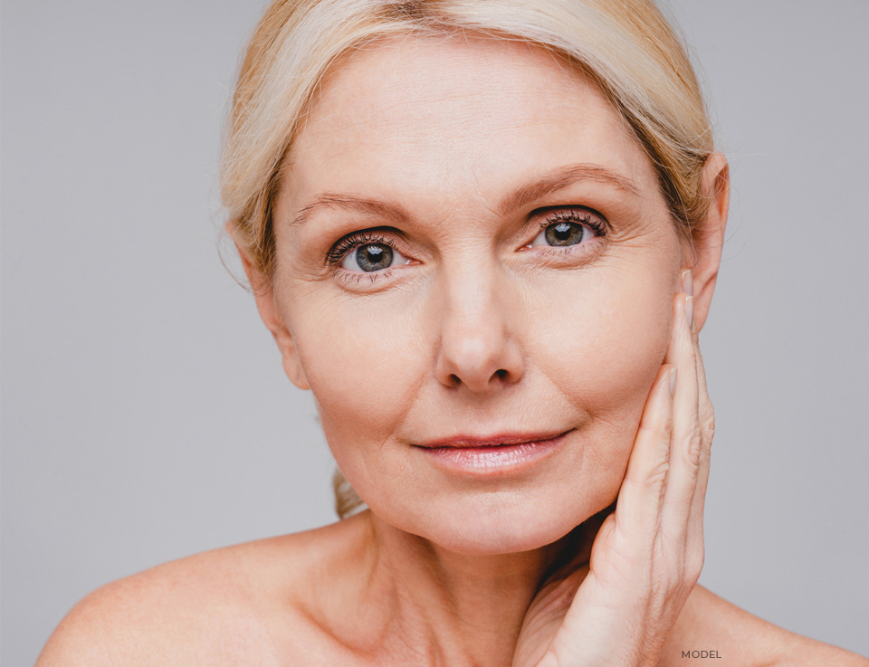 stock image of model holding her hands on her chin